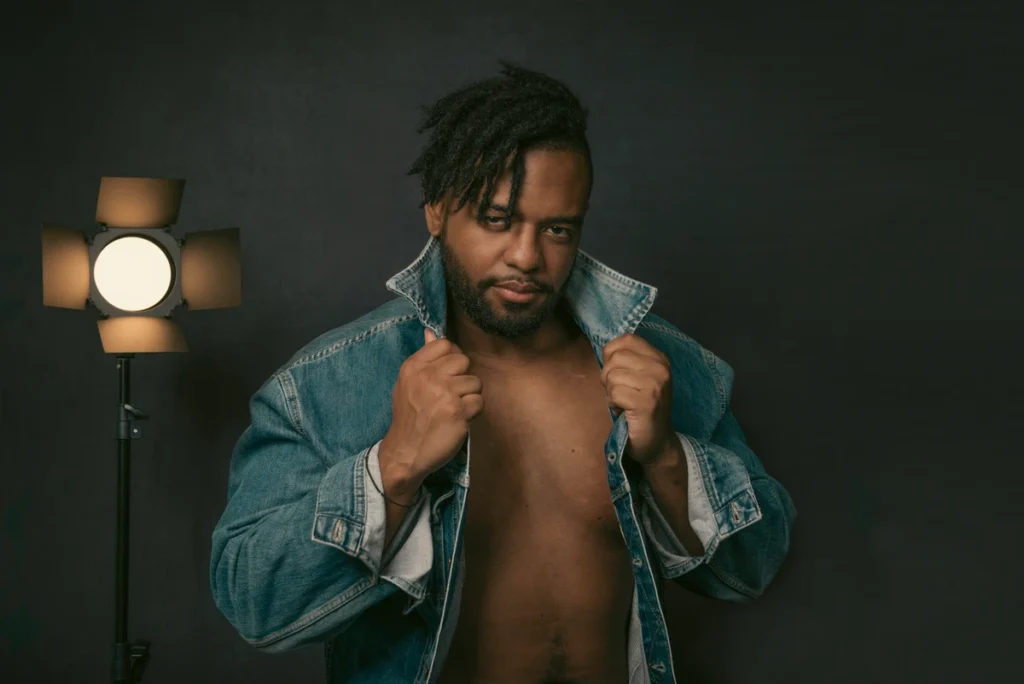 a man looking at the camera wearing a jean jacket during a boudoir shoot in austin tx