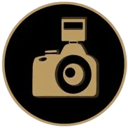 Gold outline illustration of a camera with a flash on a black circular background